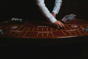 Dealer chia bài tại bàn casino trực tiếp trong studio hiện đại